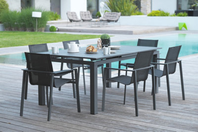 Une table de jardin avec des chaises près d'une piscine