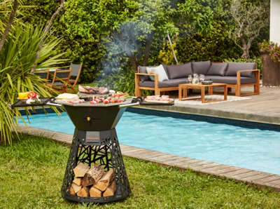 Un barbecue avec des aliments en cuisson devant une piscine