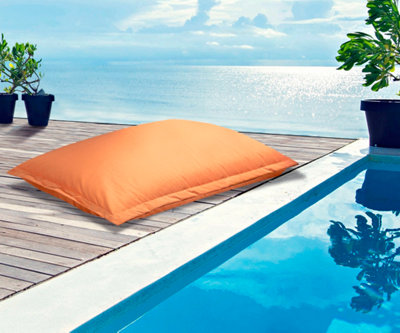 Un coussin orange fluo près d'un bassin