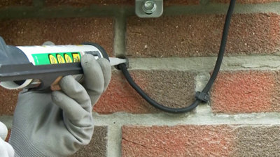 Comblez la gaine à l’extérieur avec du mastic en silicone.​
