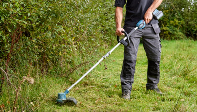 Jardinier utilisant un coupe-bordures en novembre en France pour l'entretien du jardin avant l'hiver.