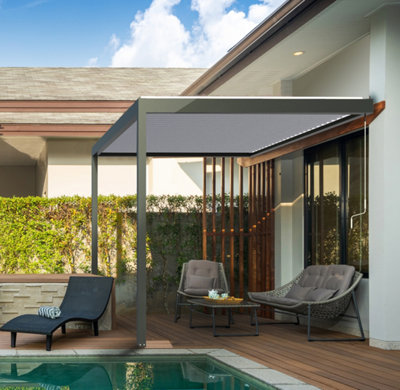 Une petite pergola bioclimatique le long d'une piscine devant une baie vitrée