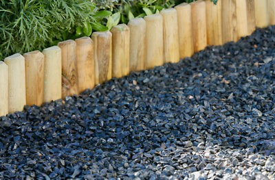 Bordure de jardin en bois le long d'une allée en graviers noirs