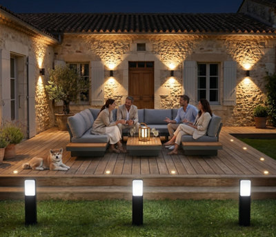 De nuit, un salon de jardin sur une terrasse éclairée par divers types de luminaires