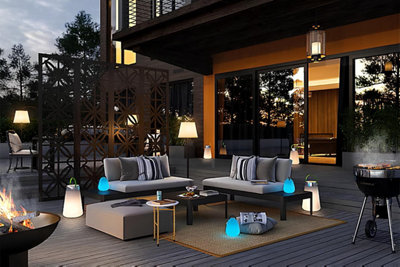 Une grande terrasse devant une maison moderne éclairée des luminaires