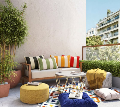Balcon avec un salon de jardin et des coussins bariolées