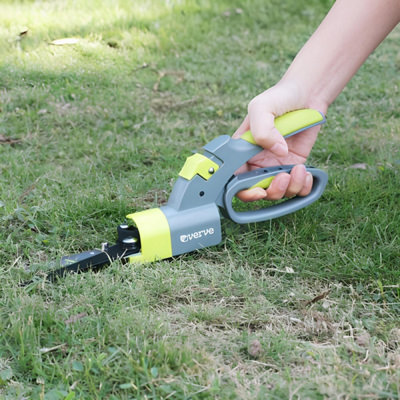 Une main taille de l'herbe avec un outil pour sculper le gazon
