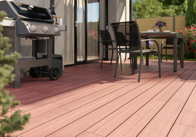Vue d'une terrasse en bois exotique avec un salon de jardin et un barbecue