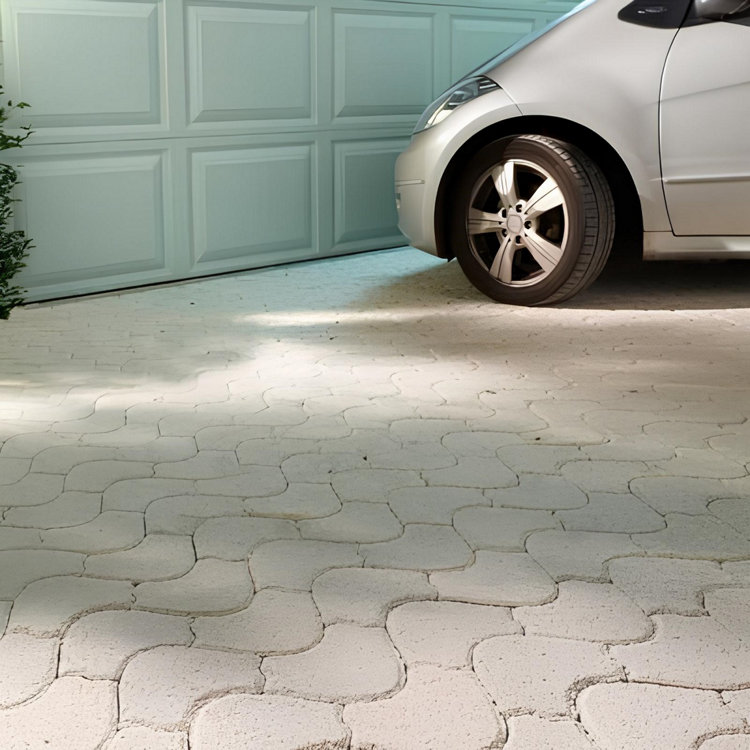 Une allée carrossable en pavés devant un garage