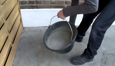 Personne appliquant la préparation du seau au sol