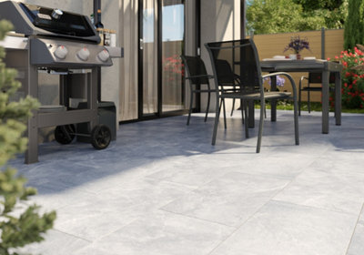 Terrasse carrelage gris clair avec salon de jardin et BBQ