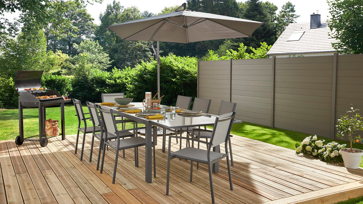 Terrasse en bois avec salon, parasol et barbecue