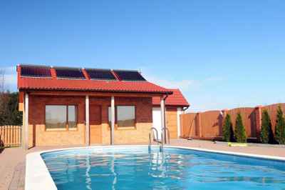 Une piscine avec un pool house équipé de panneaux solaires