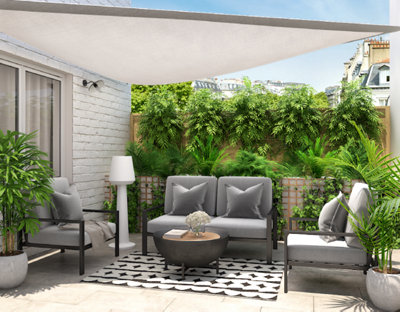 Sous une voile d'ombrage un petit salon de jardin pour orner une terrasse végétalisée
