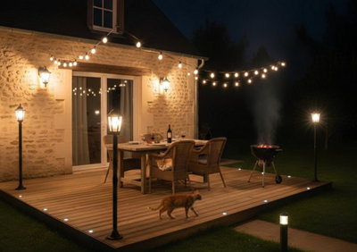 Une terrasse de maison éclairée par différents luminaires extérieurs.