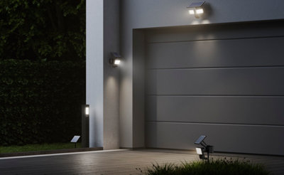 Un garage de maison individuelle équipé de plusieurs éclairages extérieurs