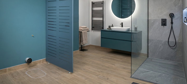 Un WC démonté dans une salle de bains avec son emplacement laissé vide