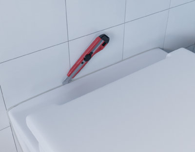 Découpe du joint des toilettes avec un cutter.