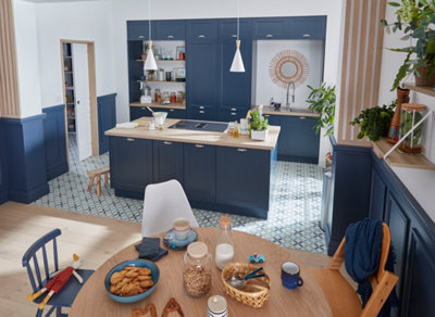 Cuisine avec un îlot central qui comprend une plaque de cuisson et des rangements.
