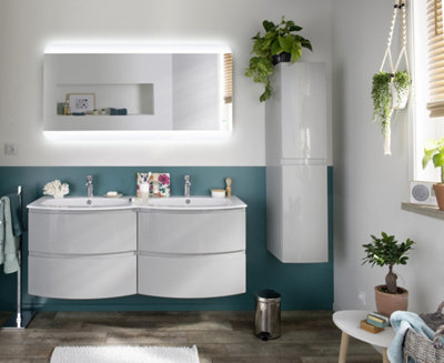 salle de bain avec un meuble vasque double, un miroir lumineux et des touches de verdure.