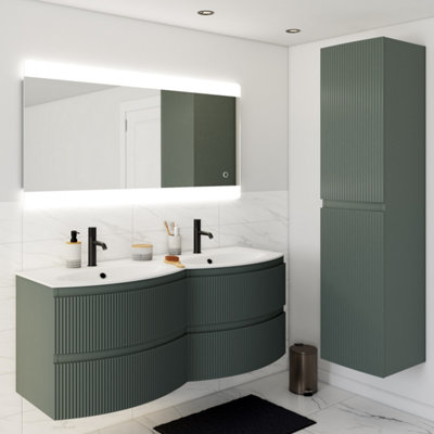 salle de bain avec un meuble vasque double vert courbé et un grand miroir rétro-éclairé.