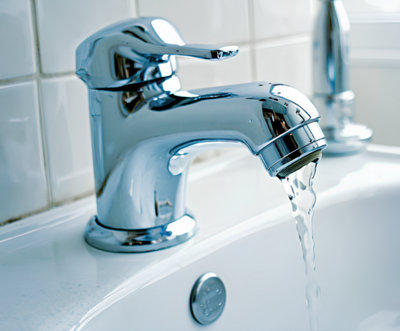 Photo d'un mitigeur avec de l'eau qui coule dans une salle de bains