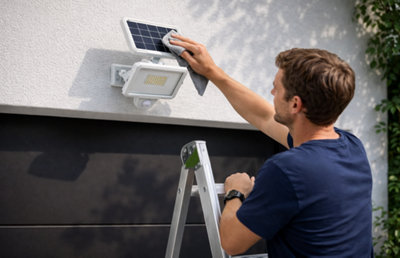 Un homme nettoie un projecteur solaire