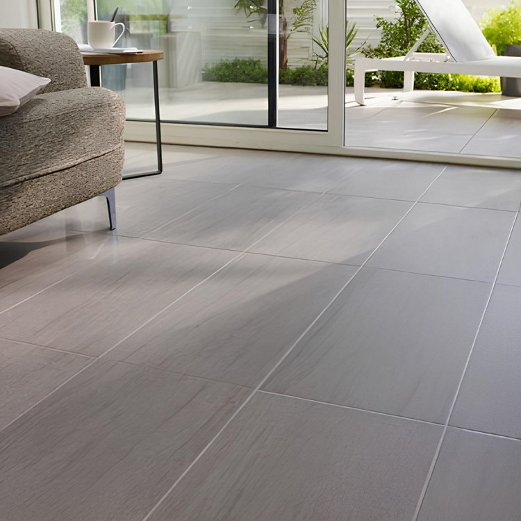 Un beau carrelage beige à grands carreaux dans un salon donnant sur un jardin