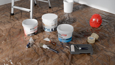 Produits pour préparer un mur étalés sur une bâche