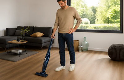 Un homme équipé d'un aspirateur sans fil nettoie un stratifié