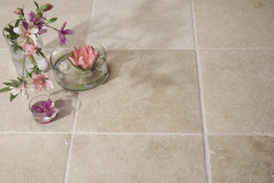 Carrelage en pierre claire avec vase de fleurs rose