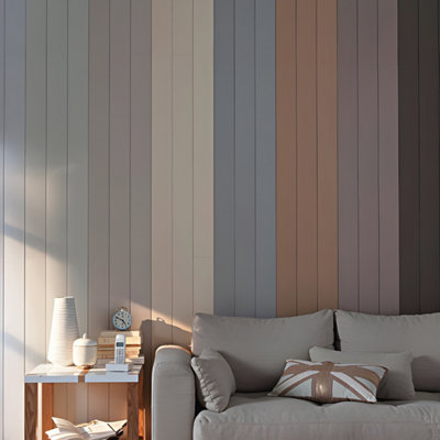 Canapé gris devant un mur lambris de plusieurs couleurs