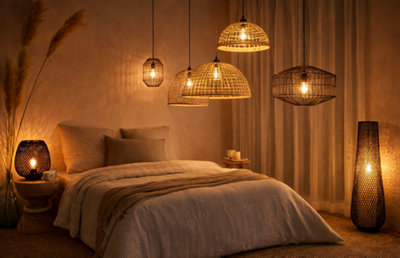 Chambre cocooning éclairée par plusieurs suspensions en rotin et métal aux lumières chaudes, créant une atmosphère douce et chaleureuse.