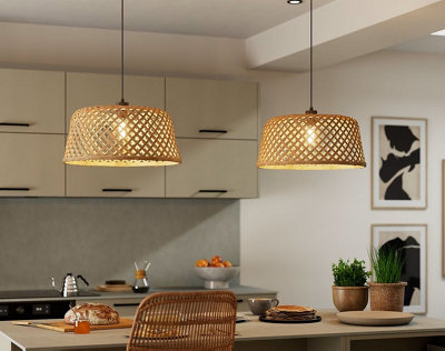 Cuisine moderne éclairée par deux suspensions en bambou tressé. Un luminaire naturel et chaleureux pour une ambiance conviviale au quotidien.