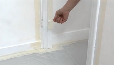 Personne qui retir ruban de masquage autour de l'encadrement de la porte