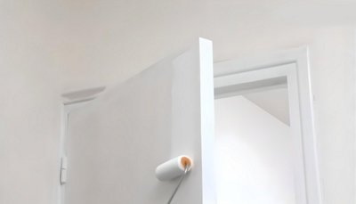 Personne qui peint la porte au rouleau