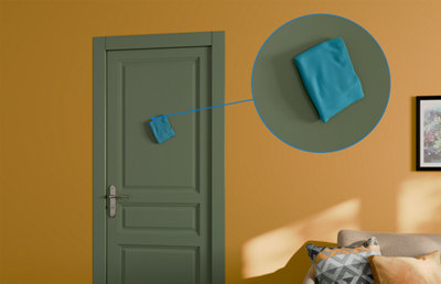 zoom sur éponge qui nettoie une porte peinte en vert
