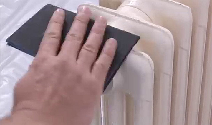 Personne ponçant le haut du radiateur