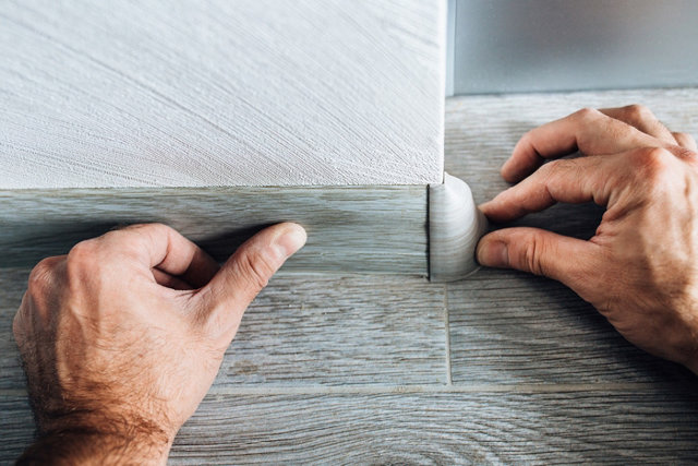 Personne appuyant sur une plinthes gris foncé