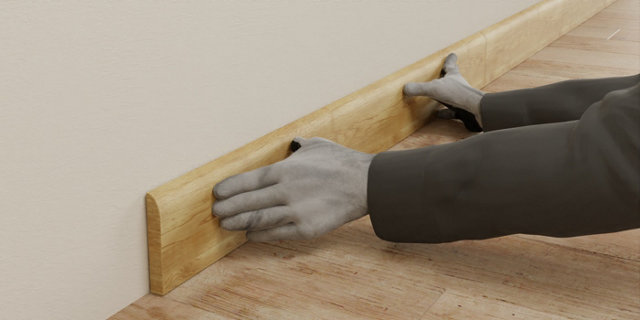 Personne appuyant sur plinthe en bois au mur