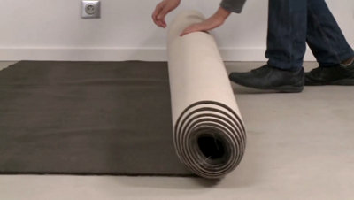 personne déroulant rouleau moquette