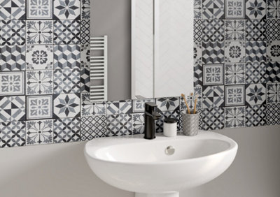 Lavabo au style vintage avec carreaux de ciment noirs et blancs et miroir.