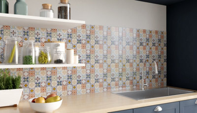 Cuisine avec crédence en carreaux de ciment colorés, meubles bleu foncé et étagères blanches.