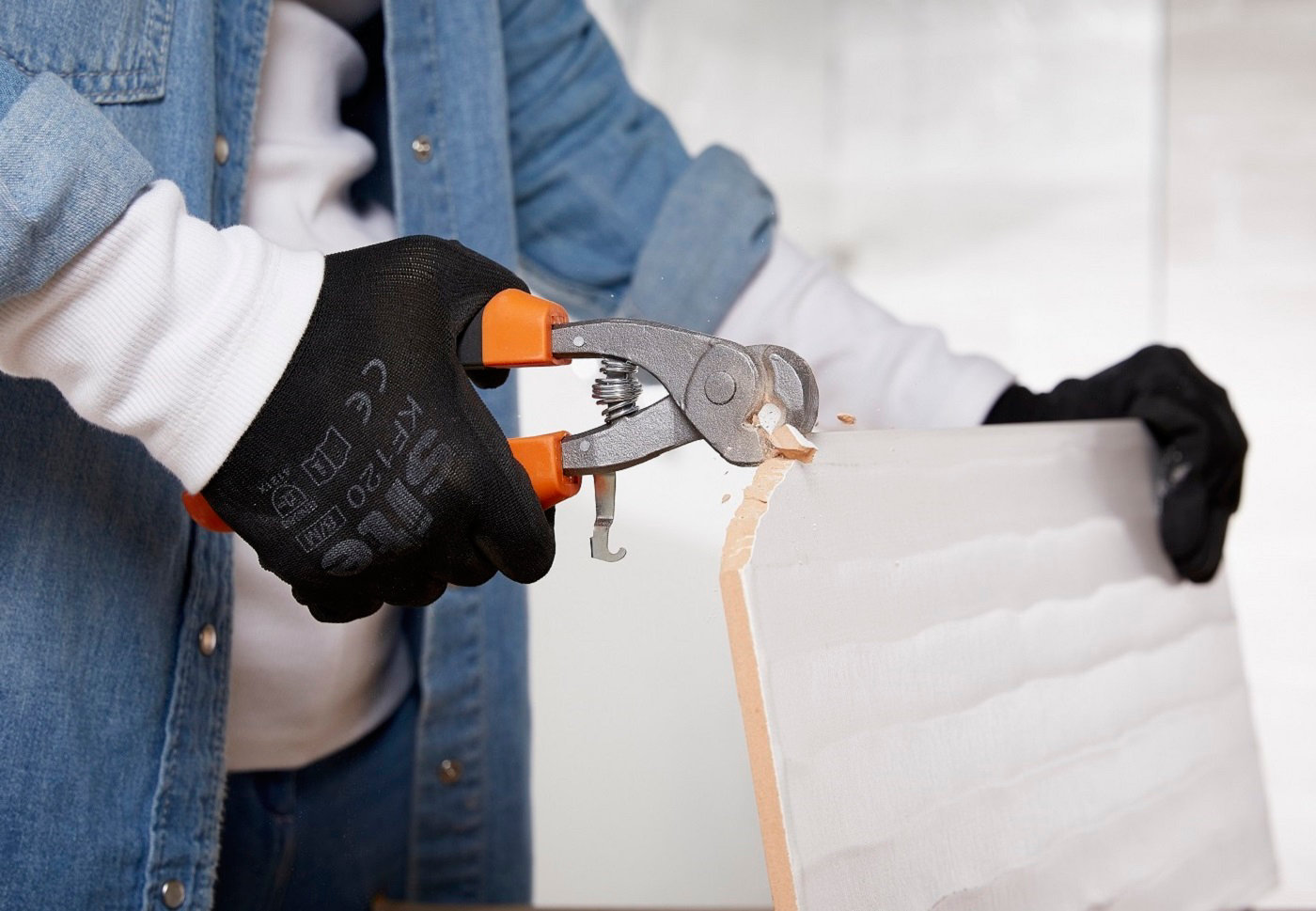 Personne utilisant pince à bec sur du carrelage