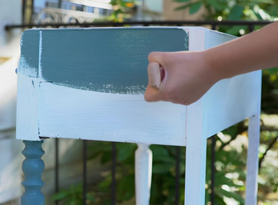 Après avoir passé une sous-couche sur un meuble, application de la peinture de rénovation