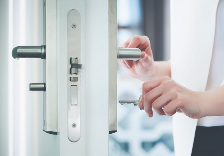 Personne insérant sa clé dans une serrure de porte