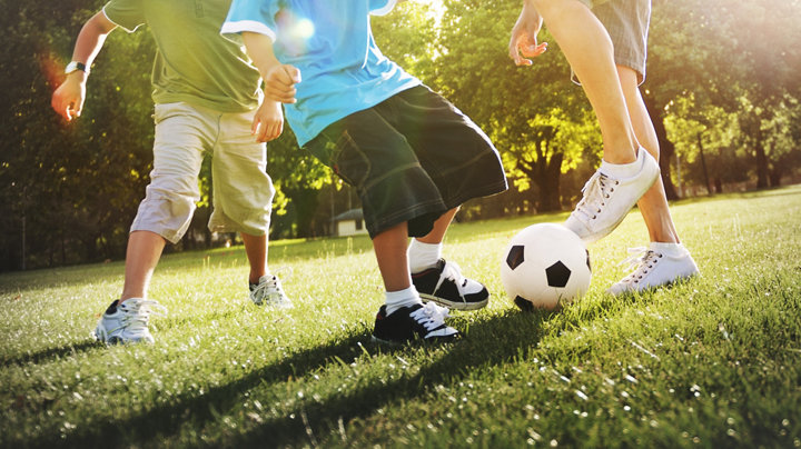Enfants jouant au foot sur l'herbe