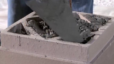 Puis remplissez votre pilier de béton à l’aide d’une truelle pour réaliser le scellement des éléments.​